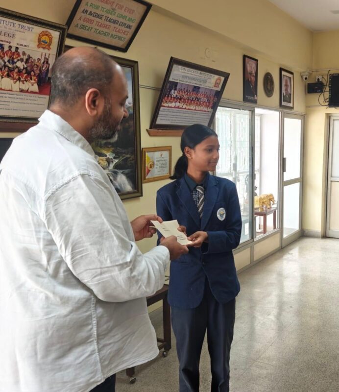 Trustee Mr. K.H. Radharaman presenting higher education scholarships to students at Vijaya English Primary School.